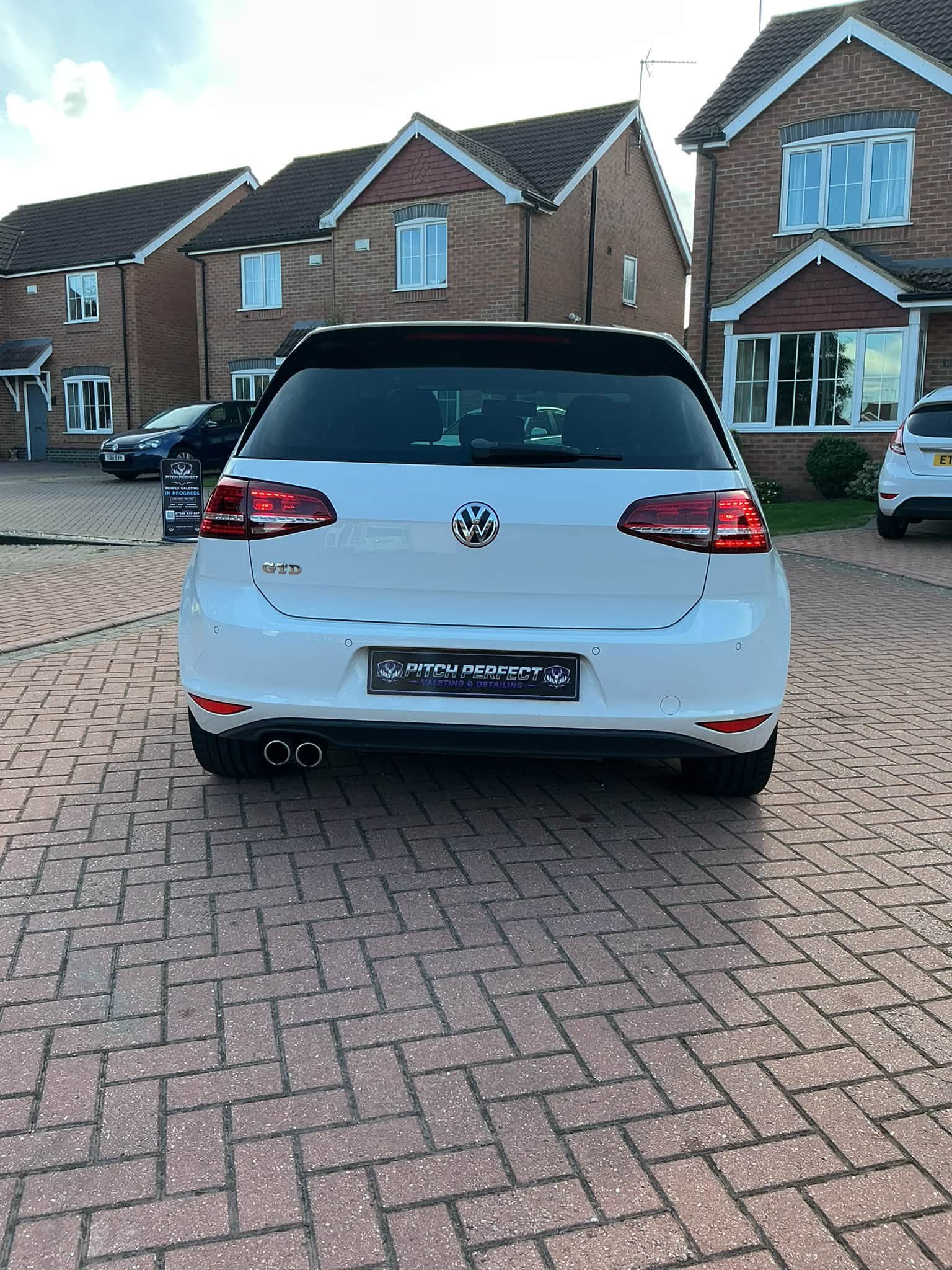 White VW Golf GTD rear with a Pitch Perfect number plate on brick pavers
